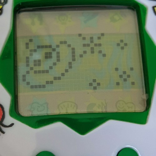 a photograph of the tamagotchi, now displaying a image of a UFO and stars, signifying the death of Gupson St Mattias Bartholomew III Montgomery